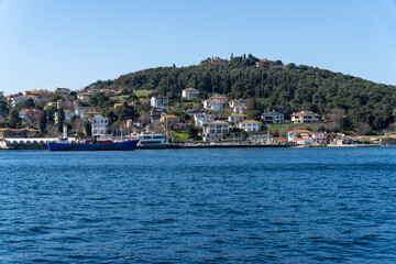 Wall Mural - A beautiful blue ocean with a small town in the background