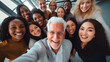 Happy diverse team having fun together. Low angle group portrait of cheerful joyful young and senior Caucasian and African American business people friends huddling, looking down at camera and smiling