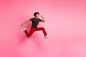 Sticker - Full body length photo of young funky curly hair positive guy jumping running marathon rush hurry up isolated on pink color background