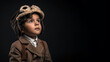 © d-AI-n - little hispanic boy dressed up as a pilot isolated on black background