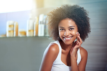 Poster - African woman, portrait and facial cream with smile, wellness or afro in home bathroom for morning routine. Girl, person and serum with cosmetics, beauty and transformation with skincare in apartment