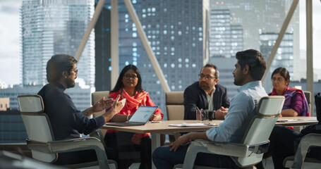 Wall Mural - Finance Department Having a Meeting to Discuss a Project with a Team Leader. South Asian Colleague Using Laptop Computer, Working in Modern Office, Employees Having a Conversation in a Conference Room