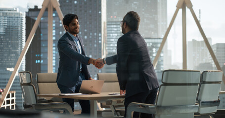 Aufkleber - South Asians Business Partners Striking a Successful Deal at a Corporate Modern Meeting Room. Two Young Indian Businessmen Shaking Hands After a Positive Negotiation Process