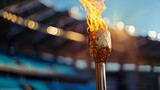 Fototapeta  - Flaming torch in a sports stadium. Olympic flame concept with copy space for design and print