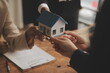 © Sutthicha - Real estate agent and Sales manager team analysis pricing of rental lease contract of sale purchase agreement, concerning mortgage loan offer for and house insurance.
