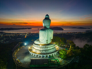 Wall Mural - Aerial view scenery yellow light at horizon at sunrise in front of Phuket Big Buddha.the golden sun shines through the clouds..The beauty of the statue fits perfectly with the charming nature.