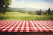 wooden table with a red checkered tablecloth on a blurred background with countryside. mockup picnic for the display of your product.