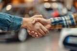 Fototapeta  - Good deal handshake close up on blurred background of cars for sale in a car showroom