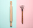 Wooden rolling pin and whisk on blue pink pastel background