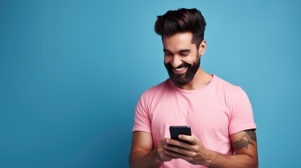 Wall Mural - Man smiling and holding her smartphone on a blue background