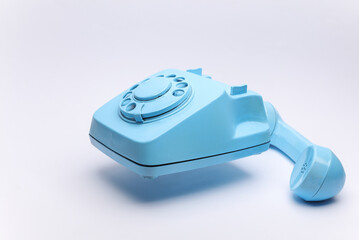 Wall Mural - Blue retro rotary phone floating on white background