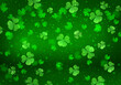 St. Patrick's Day green festive background with flying shamrock leaves, holiday party pattern with clover, abstract celebrating backdrop with glittering bokeh.
