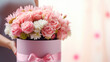 Close up of gift box with pink bouquet on gift box in female hands. Banner or gift card for Happy Mother's Day or Happy Women's day, birthday.