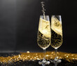 © Alena Yakusheva - flutes with champagne or fizzy white wine on black background with blurred sparkles in the back
