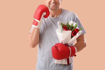 Poster - Middle-aged man in sportswear with bouquet of flowers and boxing gloves on beige background. International Women's Day