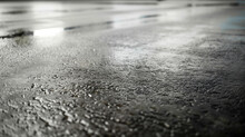 Advertising shot of perfect withour cracks wet black asphalt road texture covered with puddles highlighted with light from the side