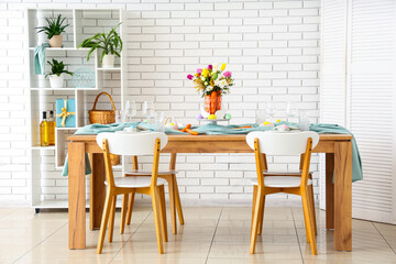 Sticker - Beautiful table setting for Easter decorated with bouquet of carrots and flowers near white brick wall