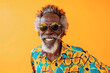 Cheerful senior African man wearing colorful vibrant clothes and sunglasses over yellow background with copy space
