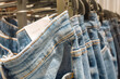 Jeans on the hanger in the store. Many jeans hanging on a rack.