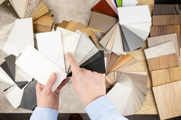 A woman looks at samples of furniture panels for furniture design. The concept of home furnishing.