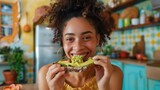Fototapeta  - a woman happily eating smashed avocado on toast in a colourful kitchen