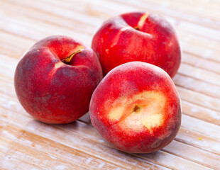 Wall Mural - Closeup of whole ripe red peaches on wooden table. Vitamin fruits