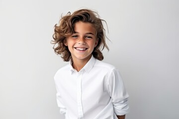 Wall Mural - Portrait of a cute little boy in a white shirt on a gray background