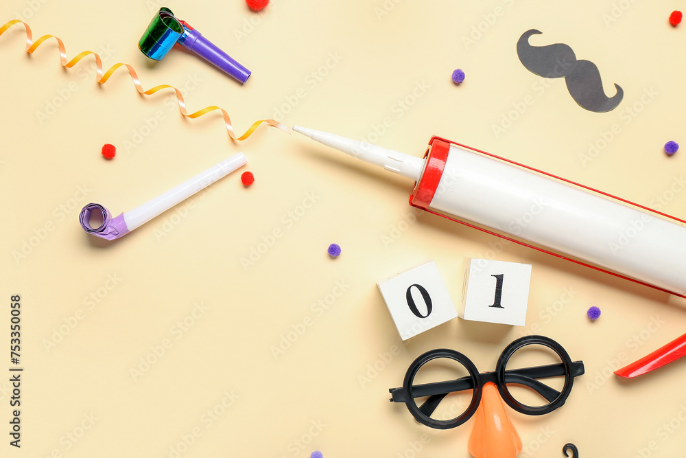 Funny glasses with construction adhesive and party decor on beige background. April Fools Day