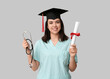 © Pixel-Shot - Happy female medical student in graduation hat with stethoscope and diploma on white background