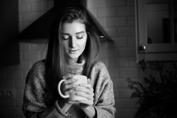 Wall Mural - A woman is holding mug in her hands