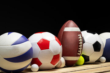 Wall Mural - Set of various sport balls on wooden floor on black background