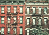 Fototapeta  - Old buildings with fire escapes, color toning applied, New York City, USA.