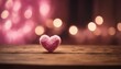 A fluffy pink heart rests on wood, bathed in warm bokeh lights, evoking feelings of love and coziness.