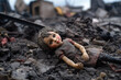 A girl doll lies among broken bricks and debris against the backdrop of destroyed houses and buildings. War, devastation and destruction