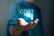 © Pakin - Cost reduction business finance concept. Budget management and cost management. Optimization, Strategy, Economic cost savings. Person holding cost icon on virtual screen.