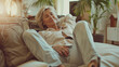 © Ayan - Cheerful Sleepy Blonde Older Lady Lying on Couch, Leaning Legs and Feet on Soft Back, Enjoying Leisure, Lazy Break in Modern Home Interior, Ai Generated Image
