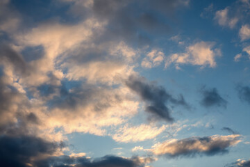 Cloudy sky in golden sun rays in sunset or sunrise, natural background