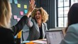 © Michael - Businesswoman giving a high five to a colleague in meeting