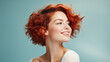 A beautiful fashionable red head woman with curly hair style and soft healthy skin smiles