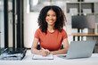 © Nuttapong punna - Confident woman with a smile standing holding notepad and tablet at the modern office.