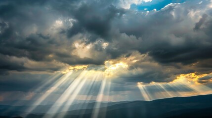 Wall Mural - Rays of light shining through dark clouds It's gonna rain, dramatic sky with cloud, Sky background on sunrise nature composition The beam of light through the dark clouds on the mountains.