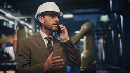 Wall Mural - Worried businessman talking smartphone at metallurgy production close up.