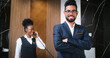 © ihorvsn - Portrait of handsome happy luxury hotel receptionist in suit looking at camera and smiling. Professional African-American hotel staff member taking calls from customers. Customer care concept.