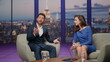 © stockbusters - Two presenter talking tv show sitting armchairs studio. Bearded man telling news