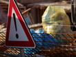 Steel reinforcement mesh and warning sign near a construction site. Rusty metal