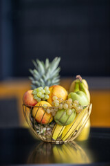 Fruit basket on the table in bright kitchen with blurred background for decoration