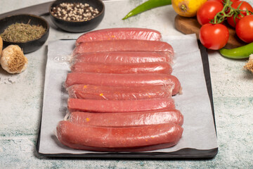 Wall Mural - Beef Sausage. Butcher products. Raw beef sausage with gelatin on stone background