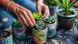 Female hands planting succulents in painted and decorated old jars. Hobby, home gardening, DIY, zero waste, sustainable lifestyle, eco friendly concept