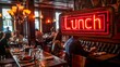 Glowing neon 'Lunch' sign hanging in a bustling restaurant with people dining and socializing in the background