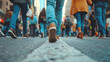 Low angle view focus on the shoe, person walking on city street during rush hour, space for text